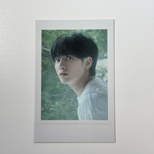 Polaroid photo of a person with dark hair, side profile, wearing a light shirt
