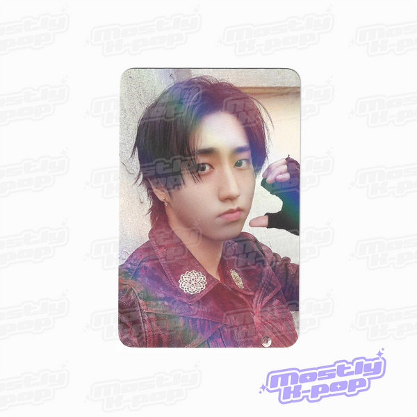 Rounded photo card of an idol portrait with dark hair, hand touching ear