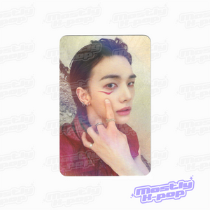 Rounded photo card of an idol portrait with hand raised near face, dark shirt