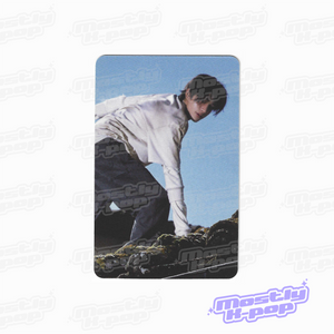 Rectangular photo card showing a person bending outdoors, wearing a light top and dark pants.