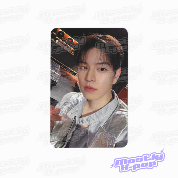 Portrait photo card of a man with dark hair, wearing a silver jacket over a gray shirt.