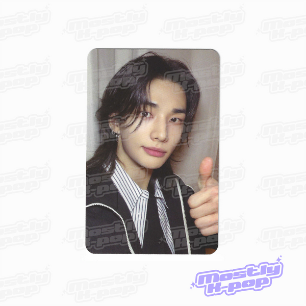 Single portrait photo card of long dark-haired member in black jacket and striped shirt