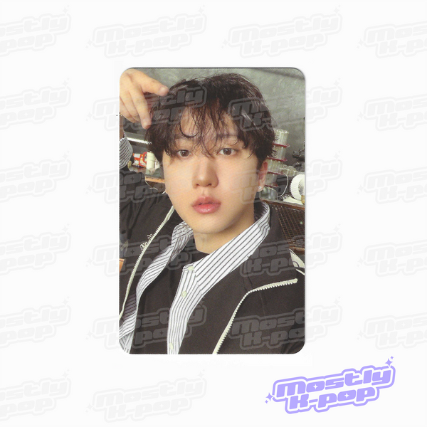Single portrait photo card of dark-haired member with hand in hair