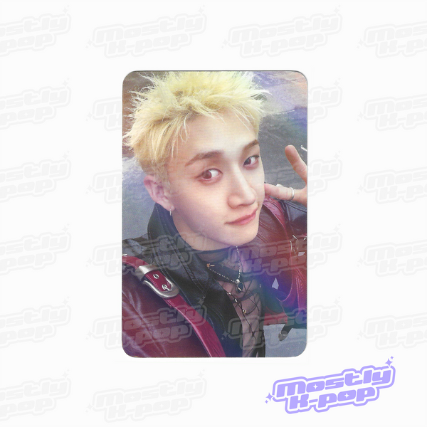 Round-corner photo card of a member with spiky blond hair, hand sign near head, iridescent