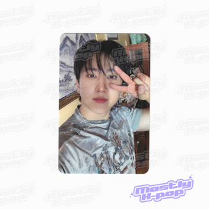 Portrait photo card of a man with dark hair, wearing a silver printed short-sleeve shirt.