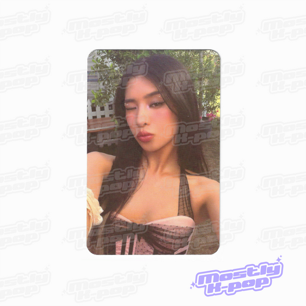 Collectible photocard showing a woman in an off-shoulder patterned top outdoors