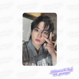 Portrait photo card of a man with black hair, wearing a dark top with silver patterned graphic.