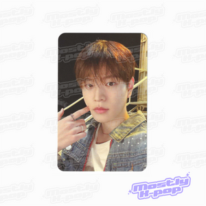 Single portrait photo card of reddish-brown haired member holding hand near face