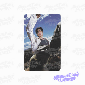 Rectangular photo card showing a person outdoors with arms raised, wearing a white top.