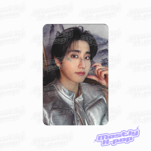 Portrait photo card of a man with dark hair and a silver leather jacket, hand near cheek.