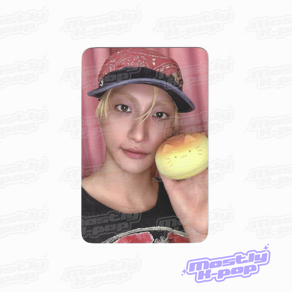 ATEEZ key chain photo card featuring a member in a cap holding a yellow character charm