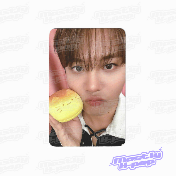 ATEEZ key chain photo card with a member holding a yellow character charm near face